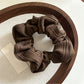 Gifty striped scrunchie paired with casual outfit on a wooden surface
