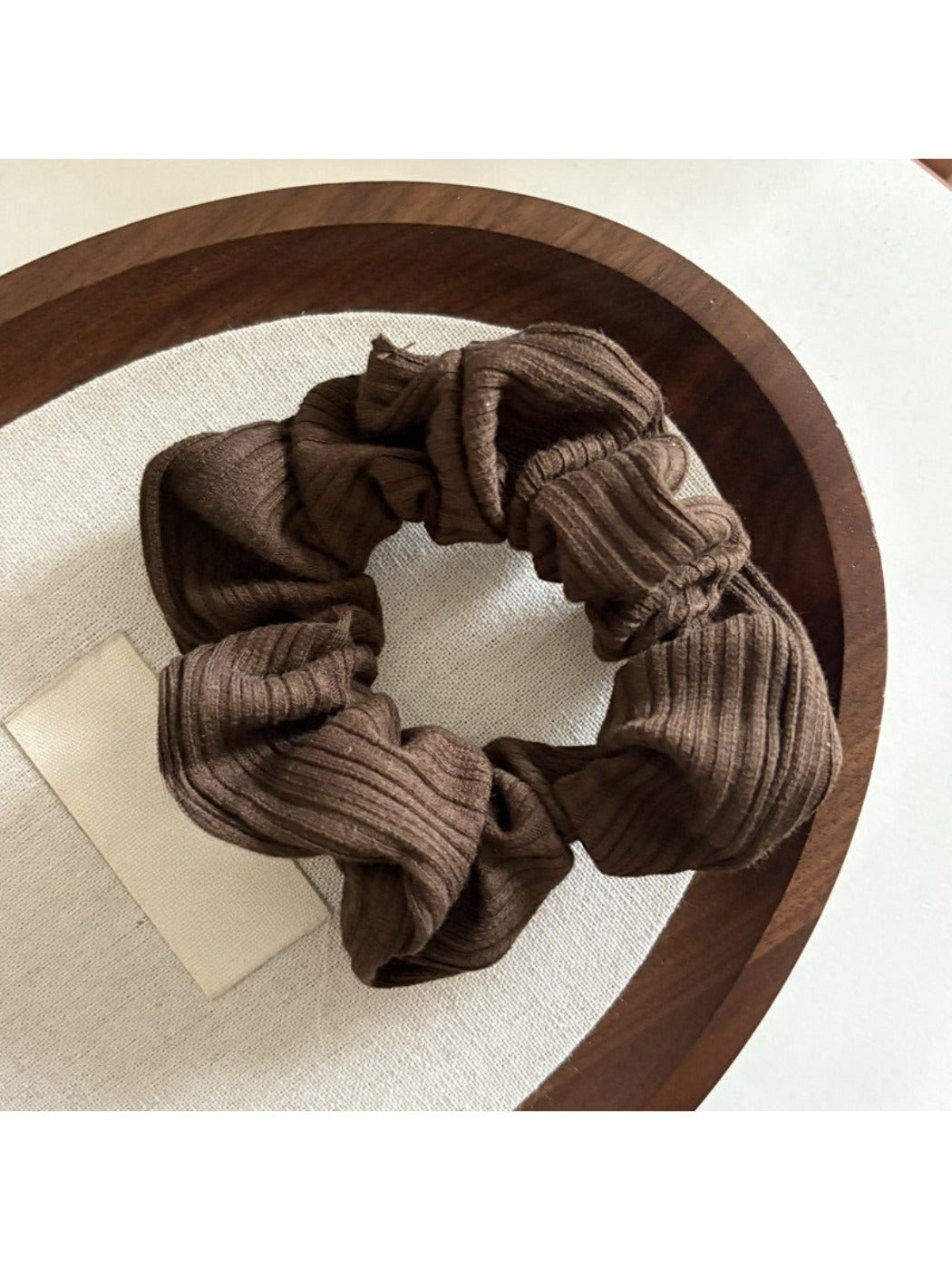 Gifty striped scrunchie paired with casual outfit on a wooden surface