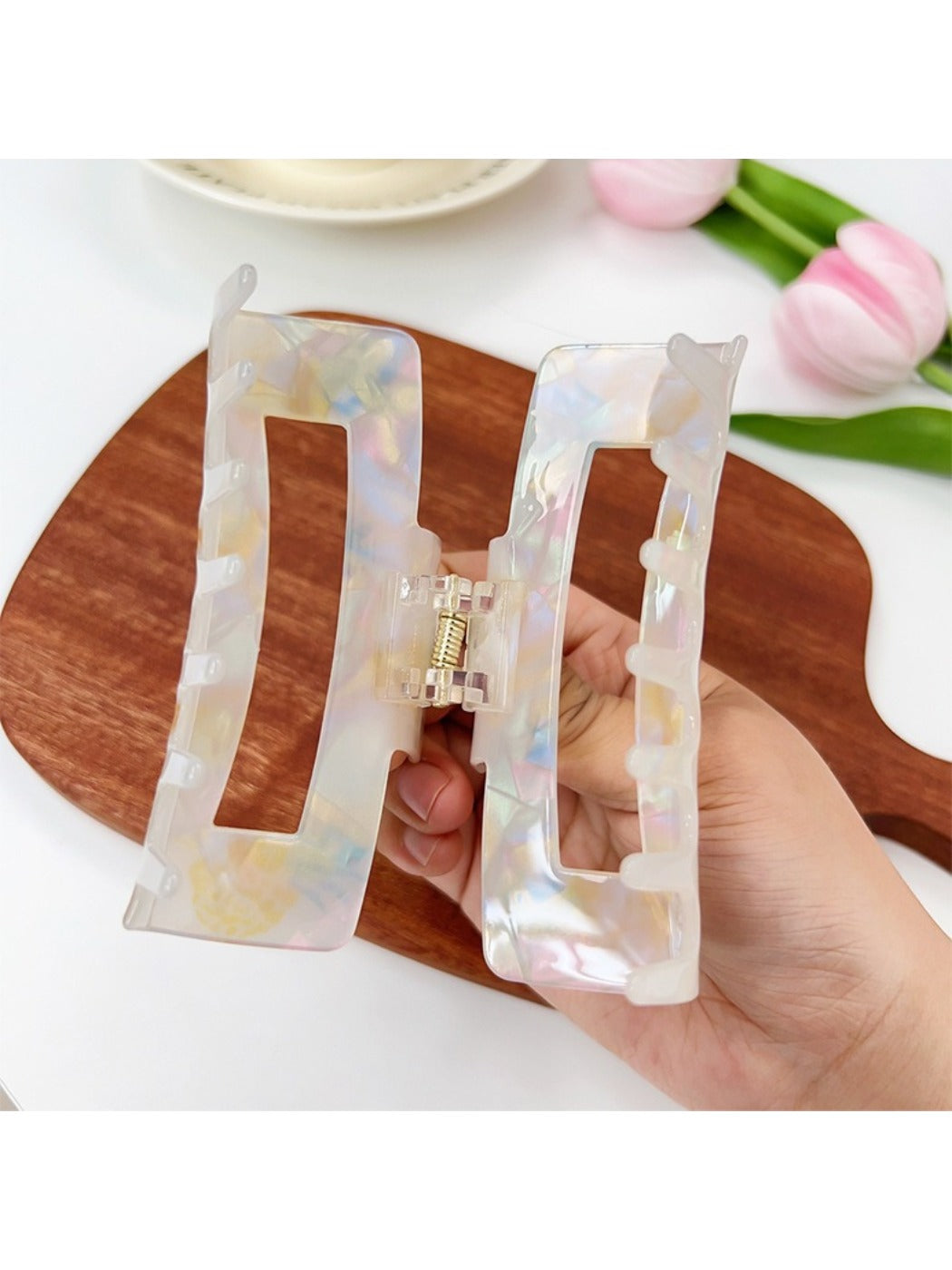 Beau claw clip held in hand displaying size and vibrant fruit print