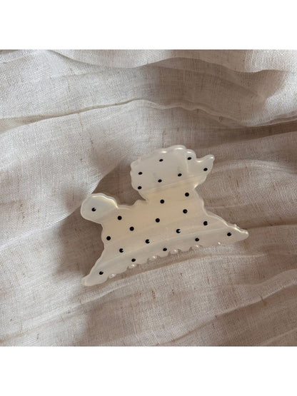 Beau polka dot puppy hair clip photographed with soft lighting emphasizing texture