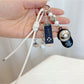 Baseball cap keychain attached to a set of keys on a wooden surface