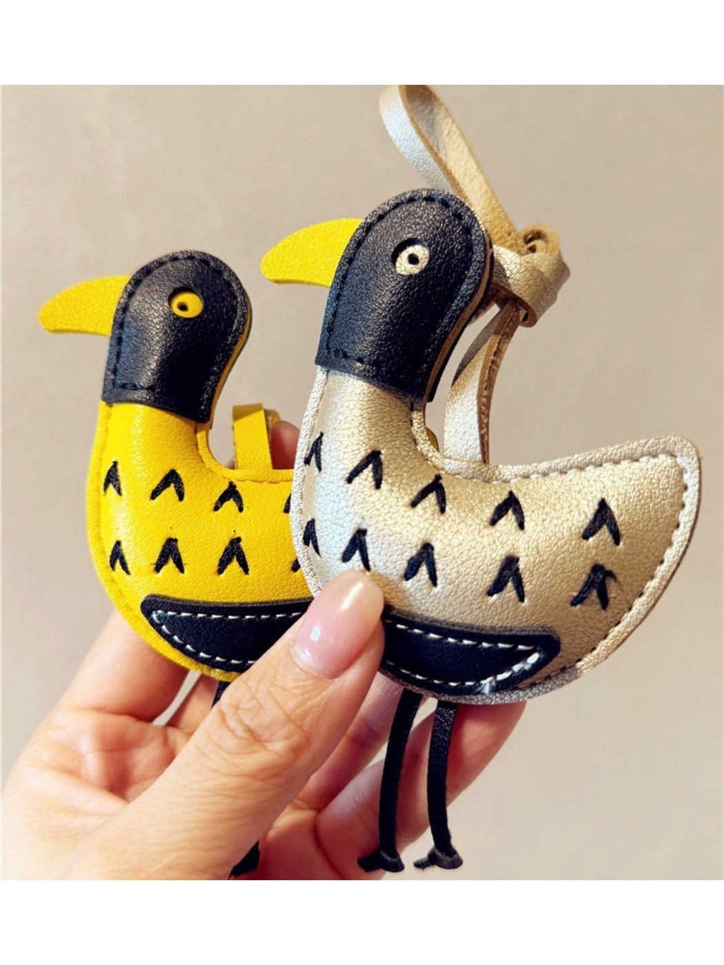 Ostrich keychain attached to a set of keys on a wooden surface
