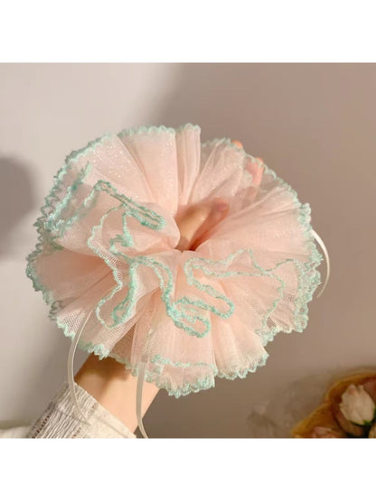 Close-up of Gifty minimalist sweet ruffle scrunchie in soft pink fabric