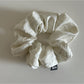 Multiple vintage pleated fabric scrunchies in different pastel colors arranged together