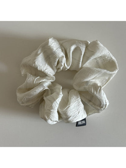 Multiple vintage pleated fabric scrunchies in different pastel colors arranged together
