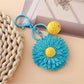 Sunflower keychain hanging from a bag strap outdoors