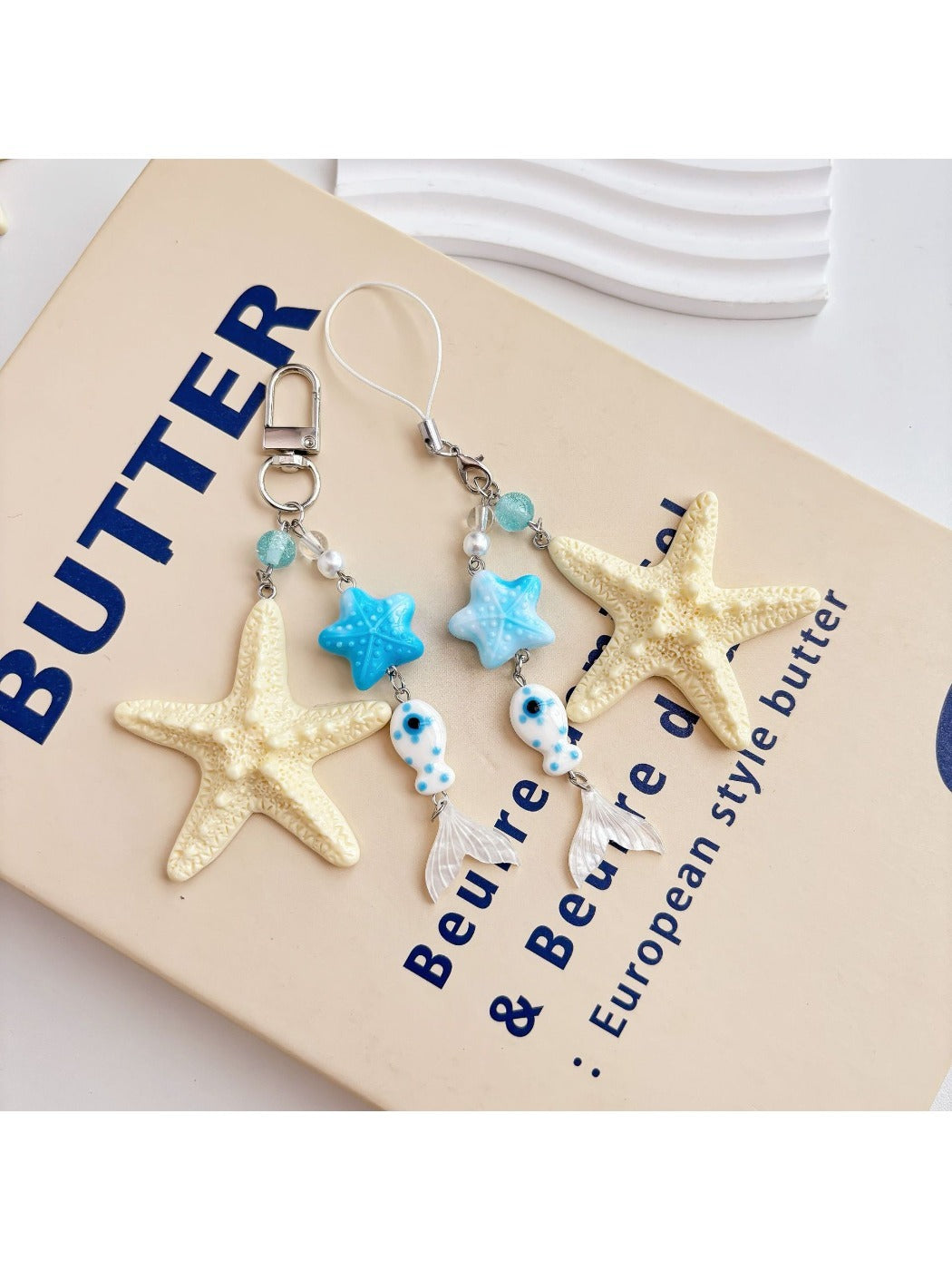 Side view of gold starfish keychain highlighting textured surface and clasp
