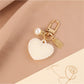Keychain displayed on a wooden surface with heart and ball charms visible
