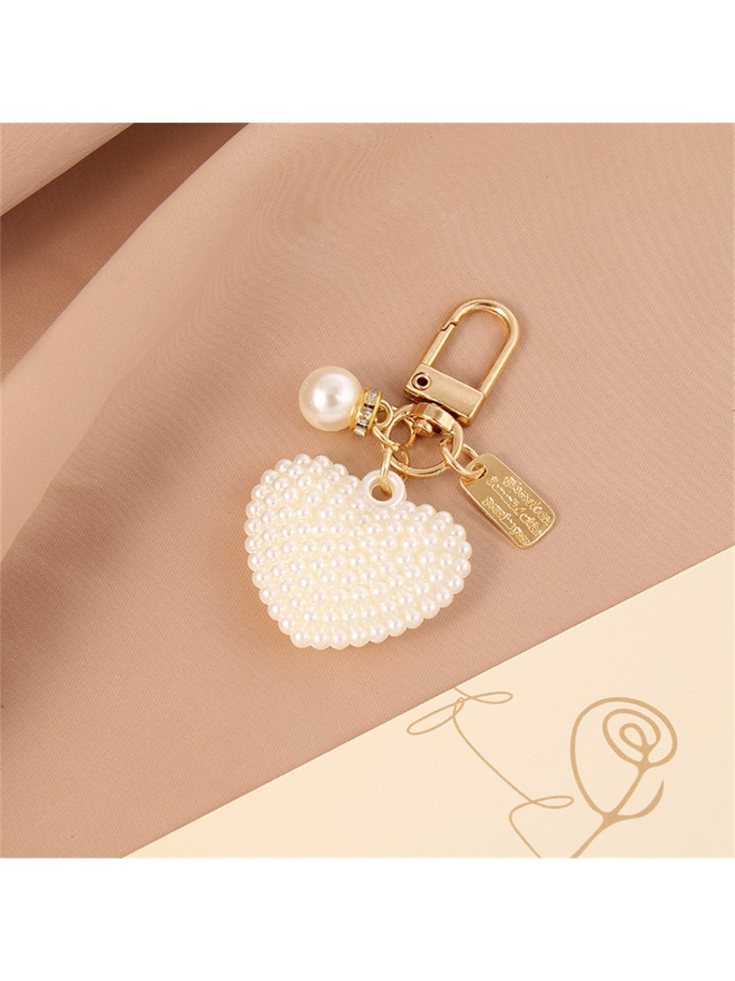 Keychain displayed on a wooden surface with heart and ball charms visible