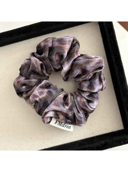 Multiple Gifty Dreamy Silky Retro Scrunchies in various pastel colors arranged in a circle