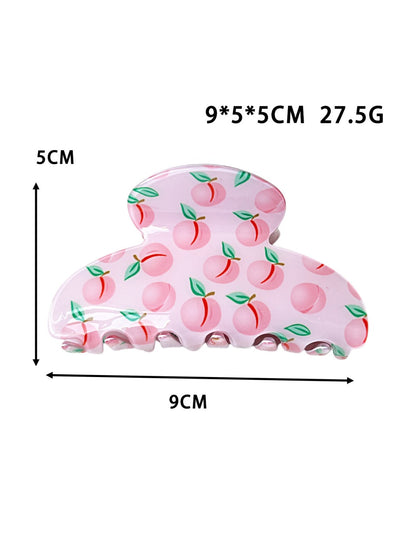 Beau claw clip holding hair, displaying vibrant fruit design