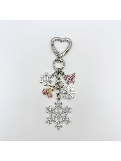 Snowflake pendant keychain attached to a set of keys on a white table
