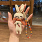 Vintage rabbit charm keychain hanging from a set of keys on a wooden surface
