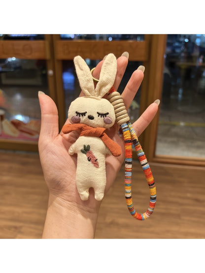 Vintage rabbit charm keychain hanging from a set of keys on a wooden surface