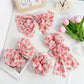 Red floral print bow scrunchie on a white background