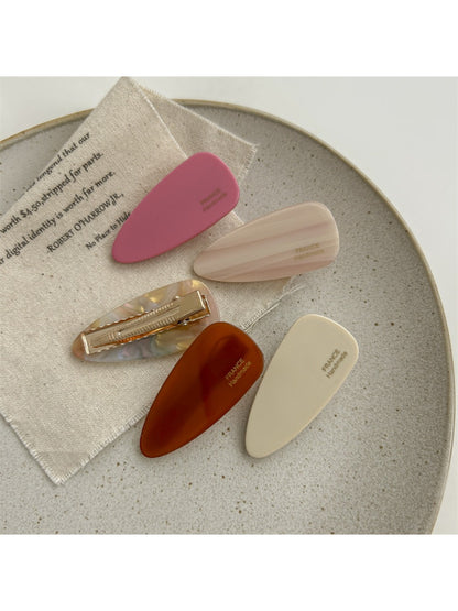 Beau pink tone hair clip clipped onto brown hair