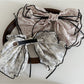 Side view of Beau tiny floral bow hair clip highlighting its curved shape and floral pattern