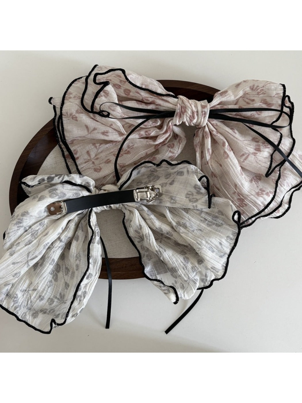 Side view of Beau tiny floral bow hair clip highlighting its curved shape and floral pattern
