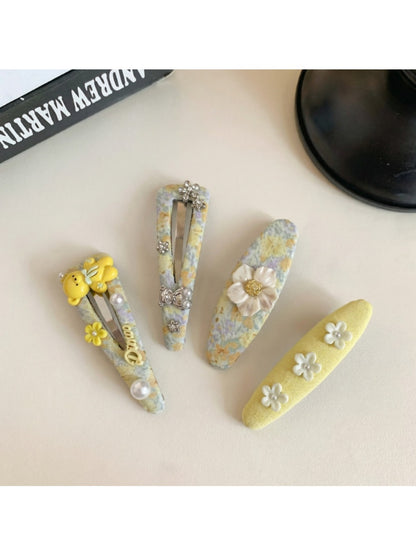 Yellow hair clip with tiny floral design clipped onto light brown hair
