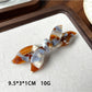 Beau bow shaped updo hair clip photographed on a wooden surface