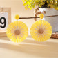Pair of sunflower shaped earrings placed inside a small jewelry box