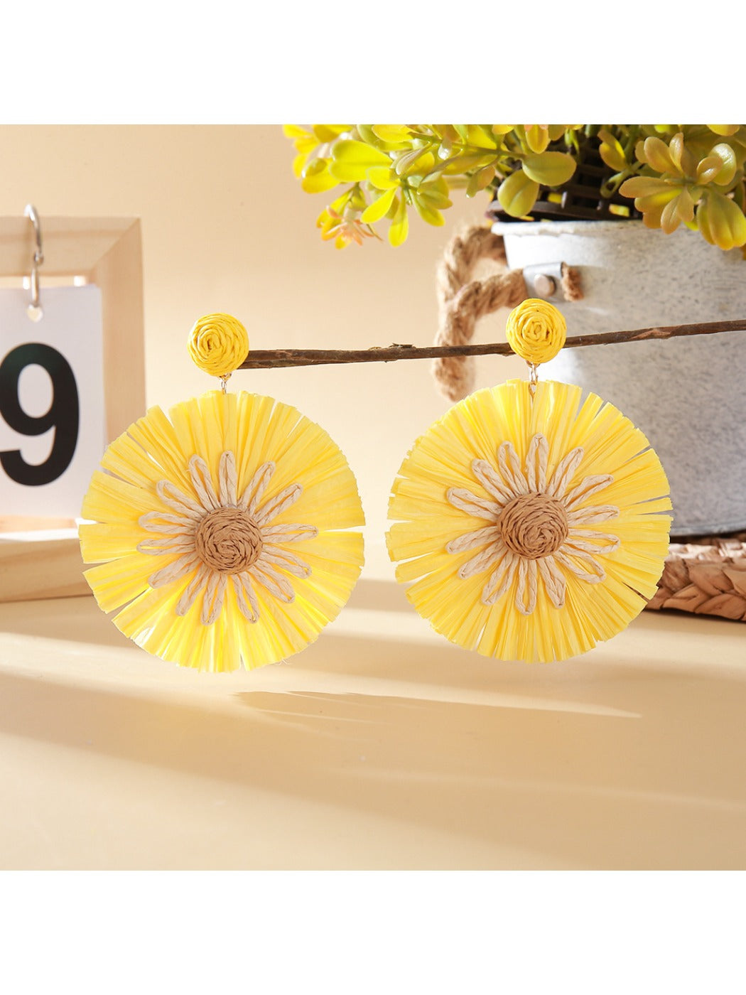 Pair of sunflower shaped earrings placed inside a small jewelry box