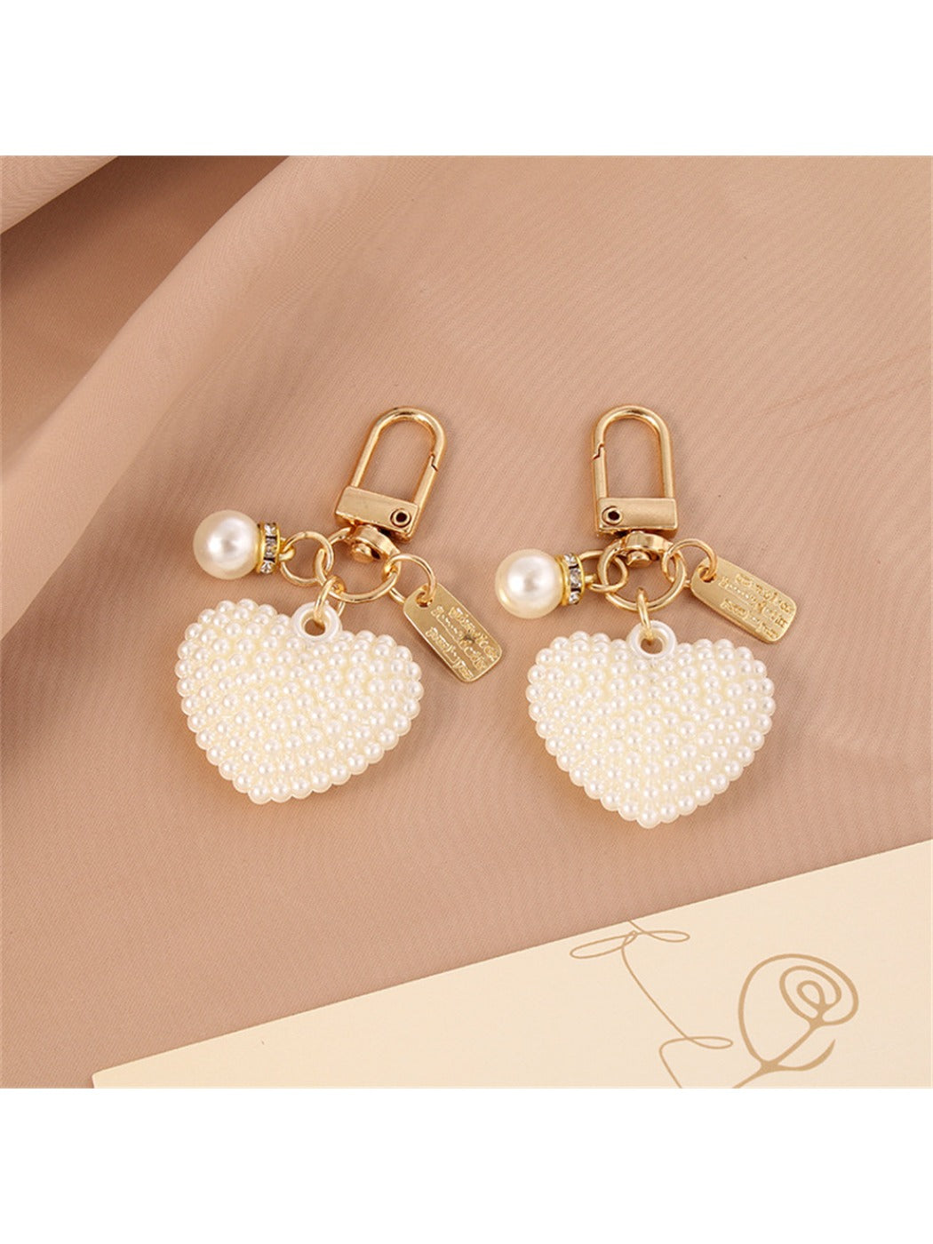 Keychain showing both heart and round ball charms hanging from a circular keyring