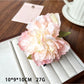 Beau lifelike peony flower claw clip resting on a wooden surface