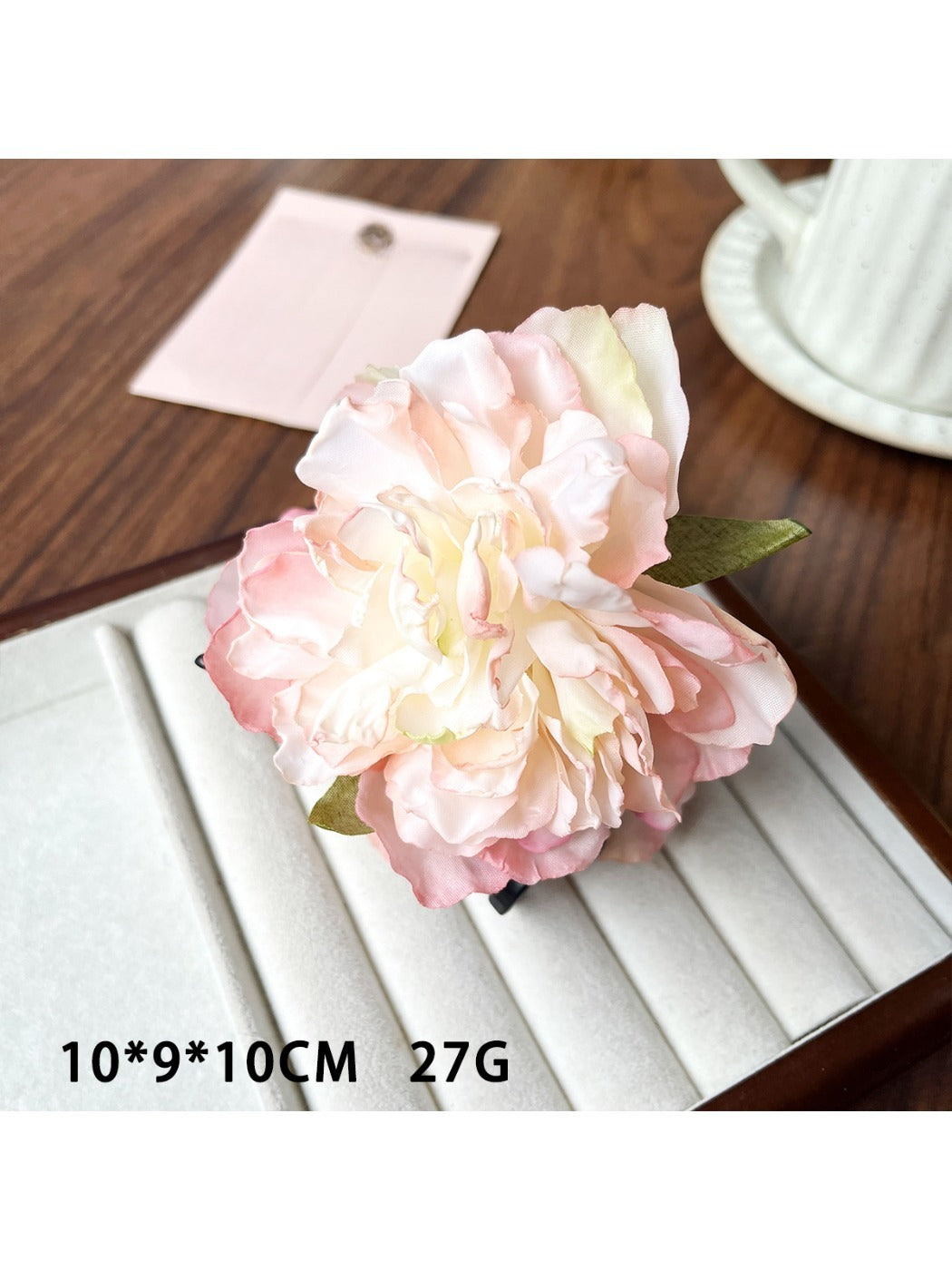 Beau lifelike peony flower claw clip resting on a wooden surface