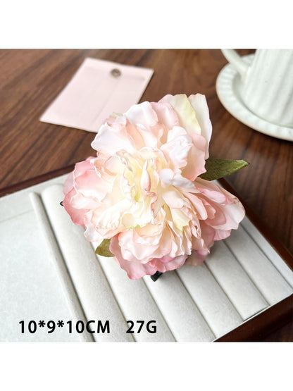 Beau lifelike peony flower claw clip resting on a wooden surface