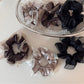 Glossy pink scrunchie with a smooth, shiny fabric texture