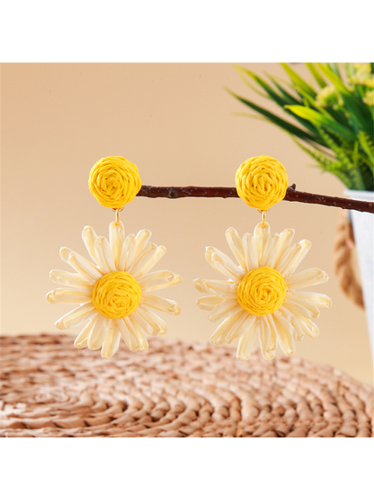 Bohemian daisy floral raffia stud earrings worn on ear with natural lighting