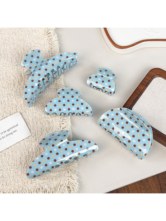 Blue hair claw clip with white polka dots on a white background