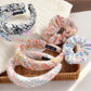 Colorful scrunchie with vibrant floral pattern on a white background