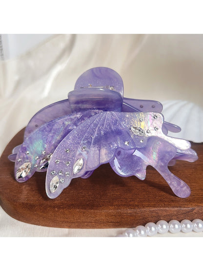 Butterfly hair claw clip holding a section of brown hair