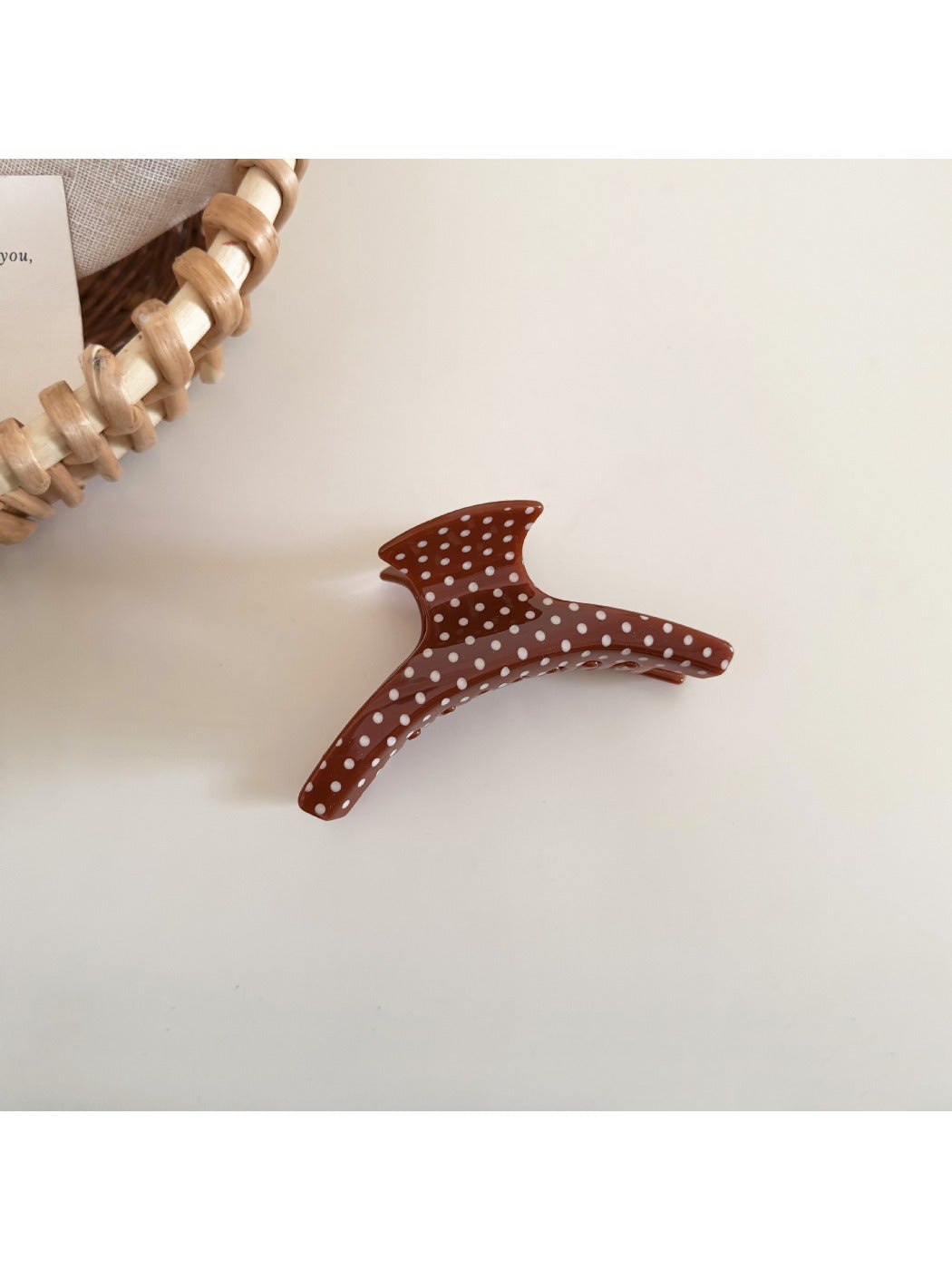 Beau polka dot acetate hair clip styled in brown hair, securing a section