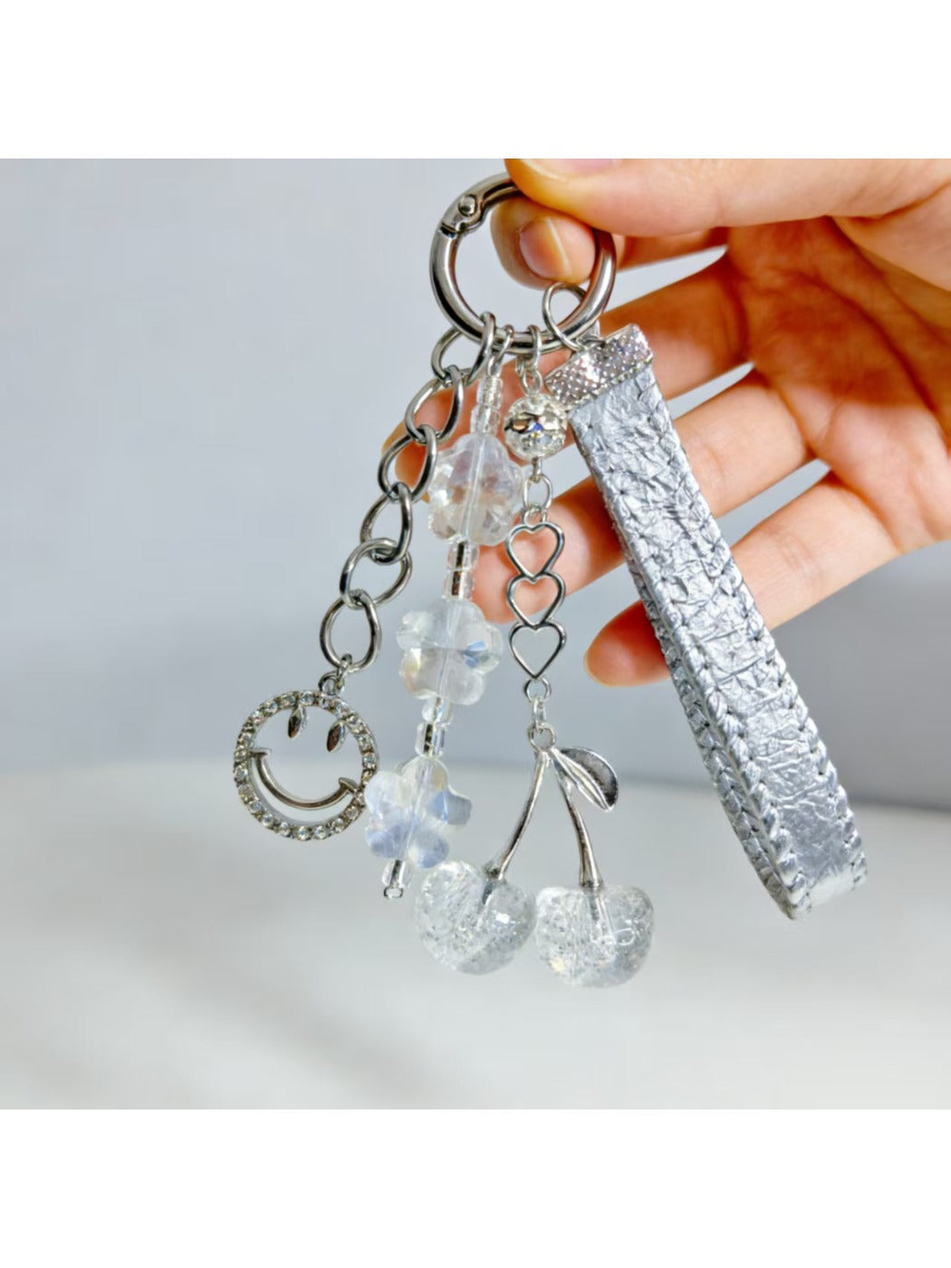 Close-up of red cherry charm on minimalist keychain with silver hardware