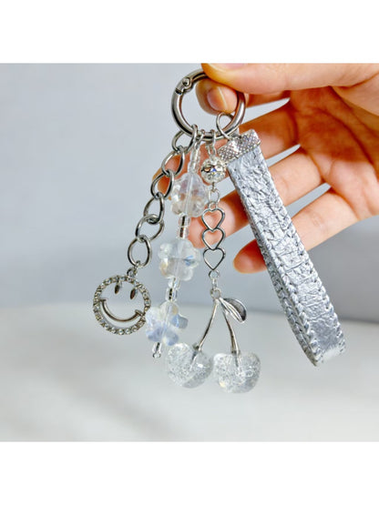 Close-up of red cherry charm on minimalist keychain with silver hardware