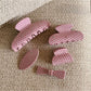 Side view of Beau pink polka dot claw clip highlighting its curved shape and clasp