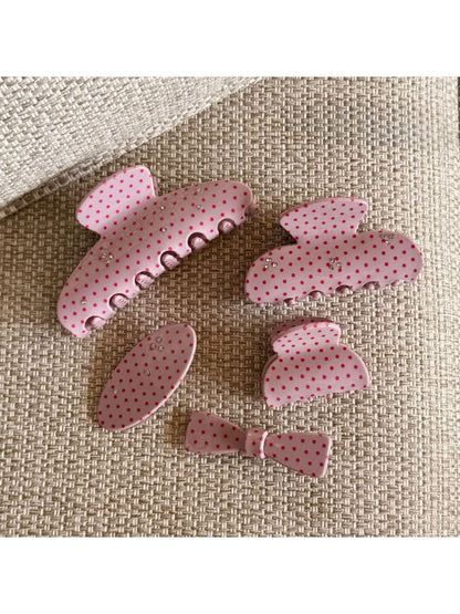 Side view of Beau pink polka dot claw clip highlighting its curved shape and clasp