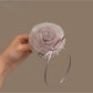 Side view of flower-embellished hair tie showing petal texture and elastic band