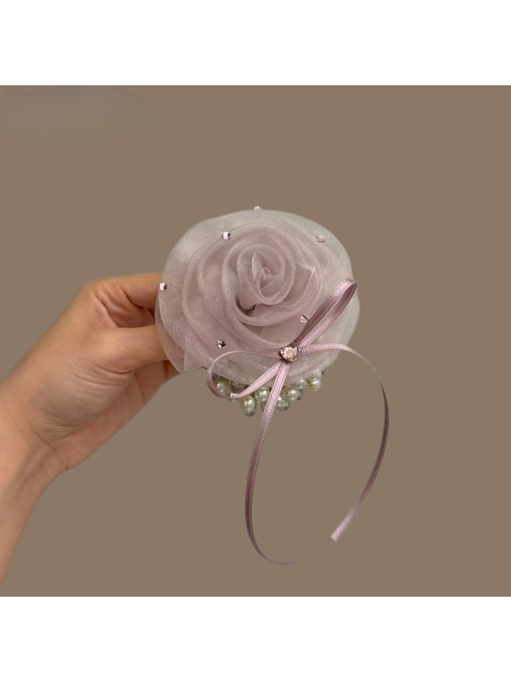 Side view of flower-embellished hair tie showing petal texture and elastic band