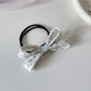 Gifty hair tie stretched to show elastic band and bow embellishment