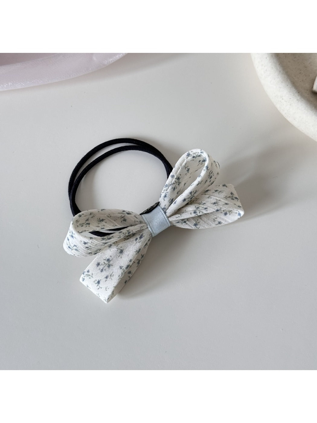 Gifty hair tie stretched to show elastic band and bow embellishment
