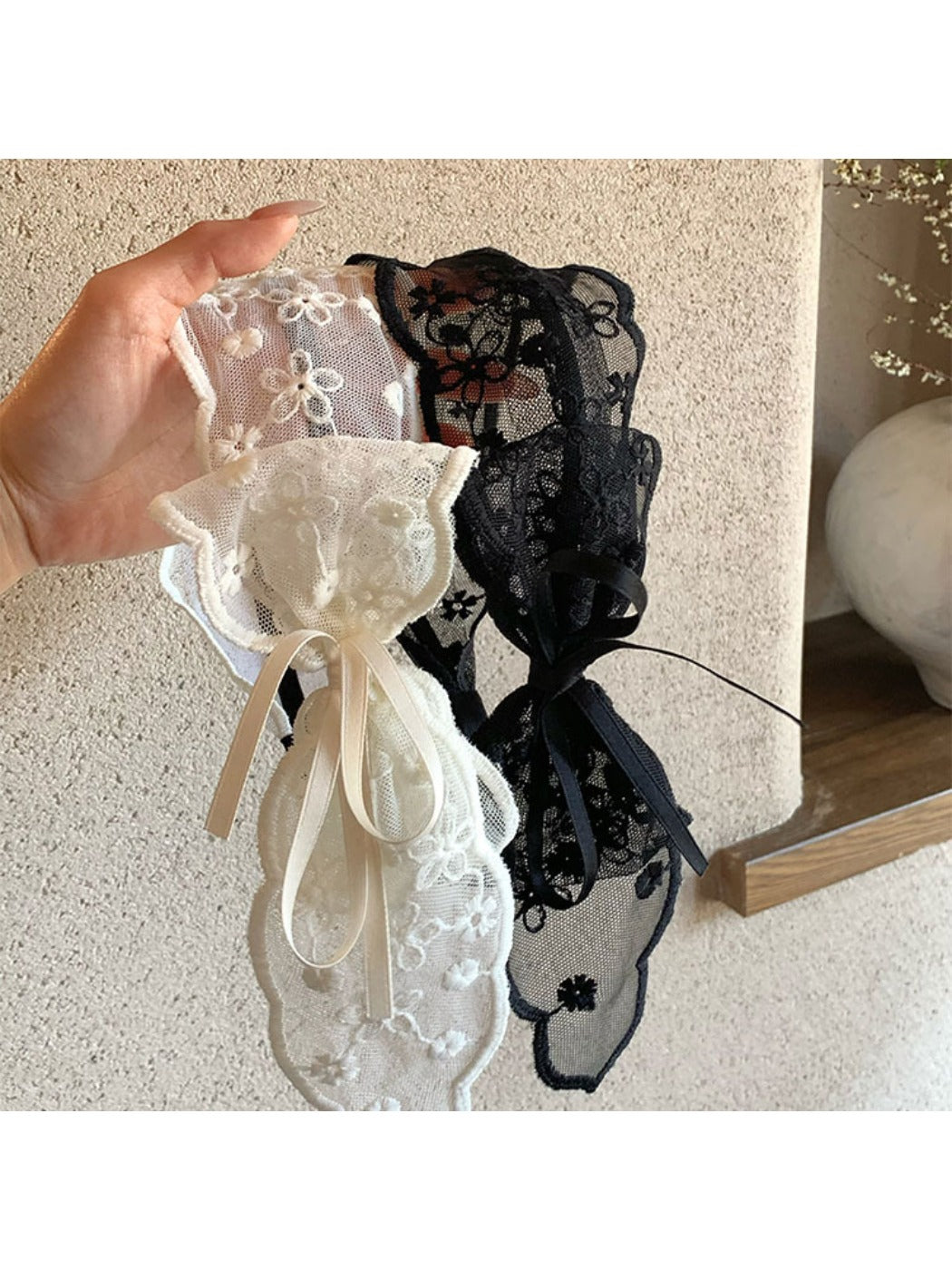 Close-up of Gifty tulle bow lace headband in soft pink on white background