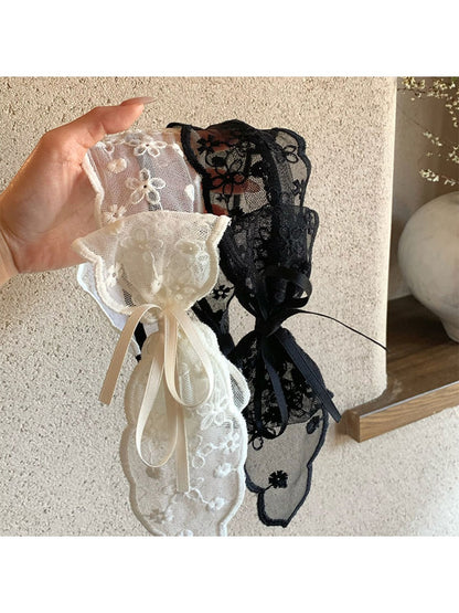 Close-up of Gifty tulle bow lace headband in soft pink on white background