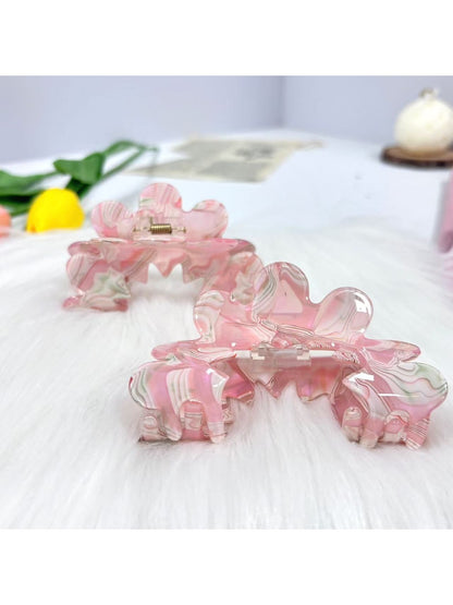 Beau wavy pink hair clip held in hand showing size and texture