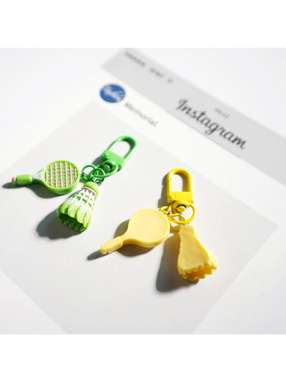 Lifelike badminton racket keychain held in a person's hand showing size