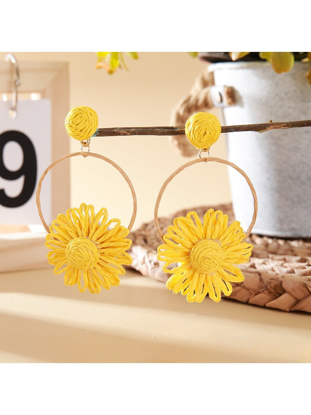 Model wearing Earedge woven raffia circle flower earrings with floral design