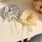 Gifty solid color bow scrunchie in soft pink fabric on white background